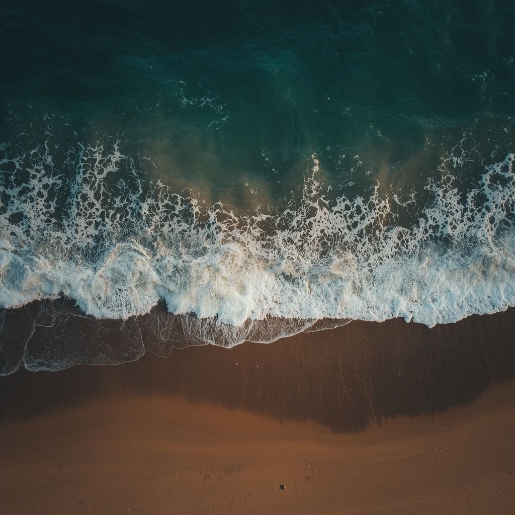 Ondas quebrando na areia, vistas de cima (imagem ilustrativa)