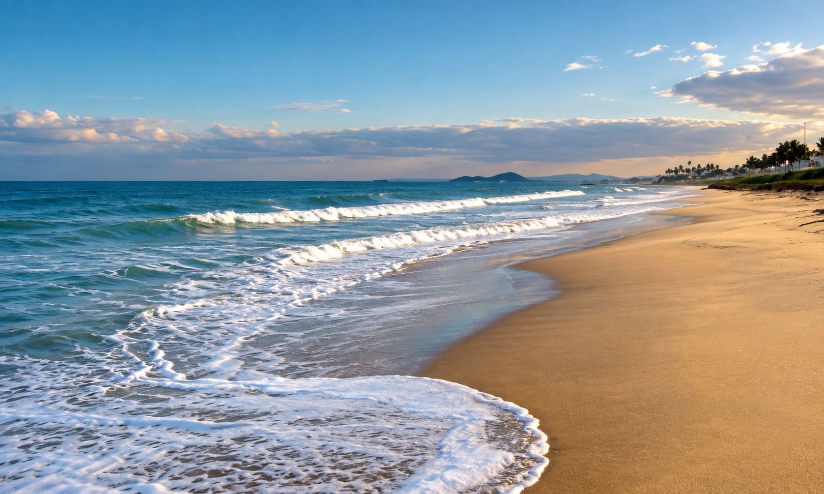 Praia com ondas e areia dourada no fim da tarde (imagem ilustrativa)